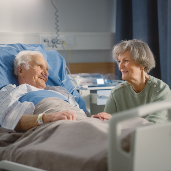 A wife comforting her husband while he is in a hospital.