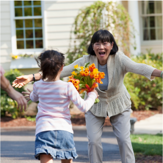 A grandmother greeting her young granddaughter with excitement, knowing she is protected with Protective Indexed Choice universal life insurance.