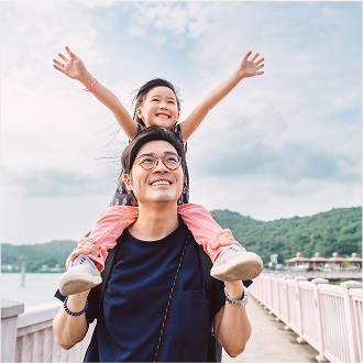A father holding her young daughter and smiling, knowing they are protected with term life insurance.